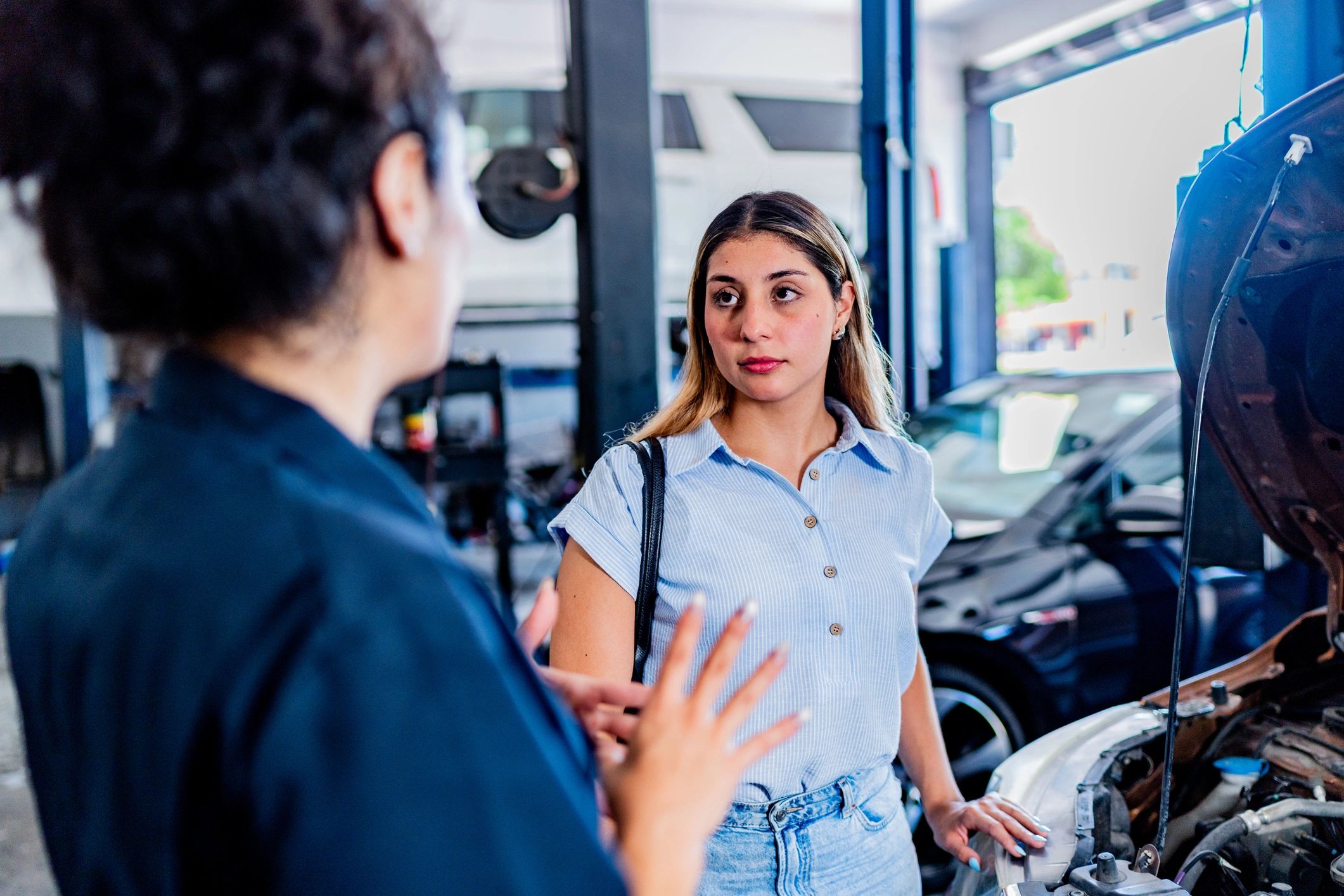 Customer standing beside a vehicle at an auto repair shop