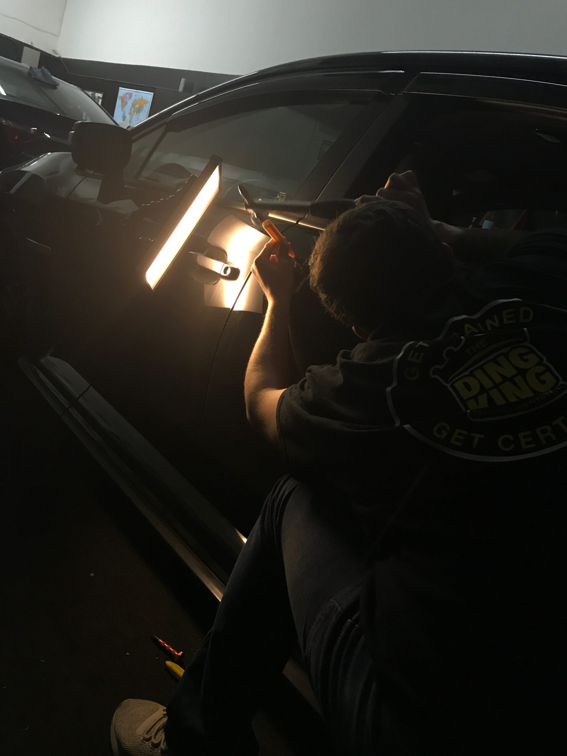 Madison Dent Repair team member beside a vehicle